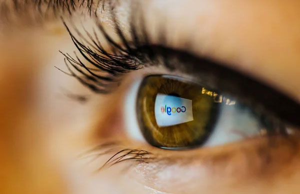 An eye with Google logo reflected on it.